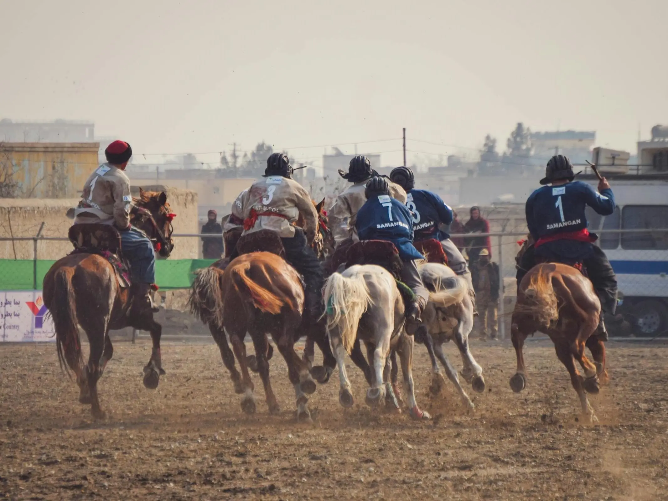 Men playing a game on horseback