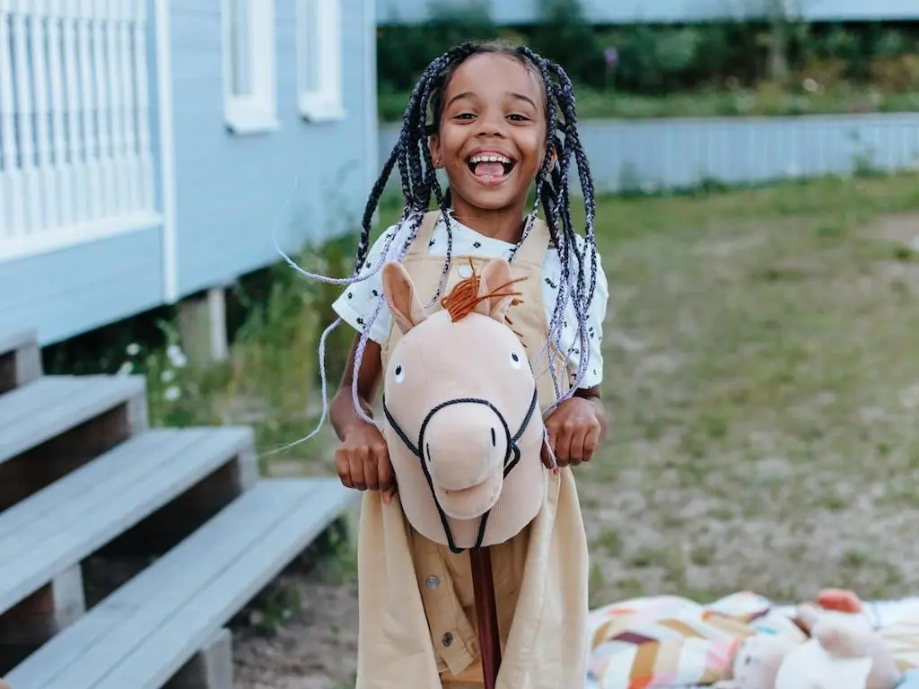 Smiling girl with a hobby horse