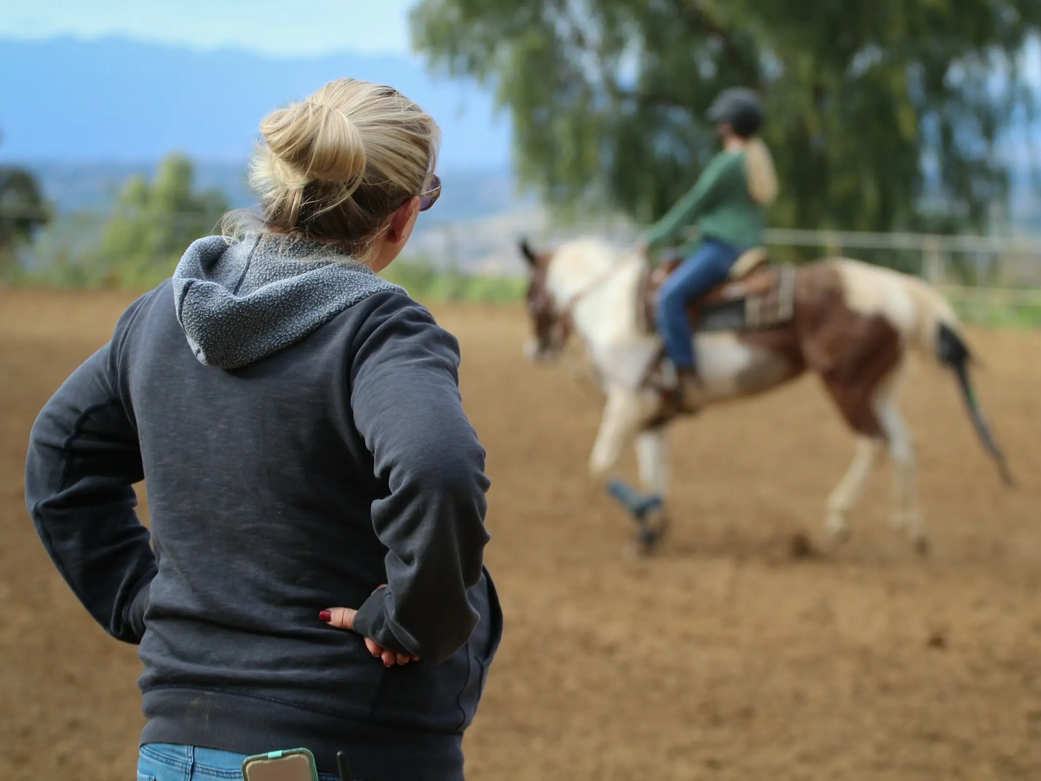 Horse trainer watching a student ride