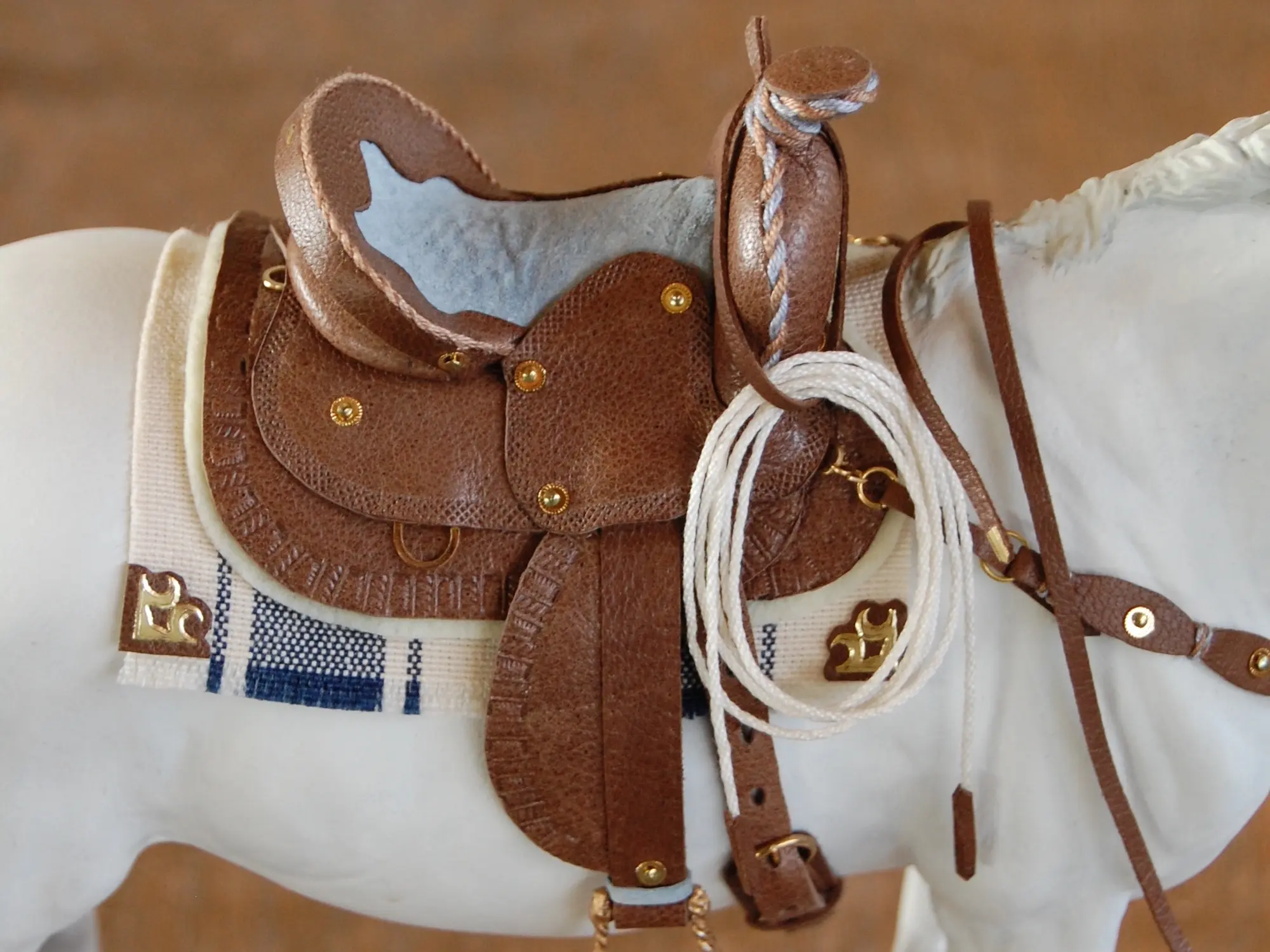 Model horse wearing miniature handmade saddle