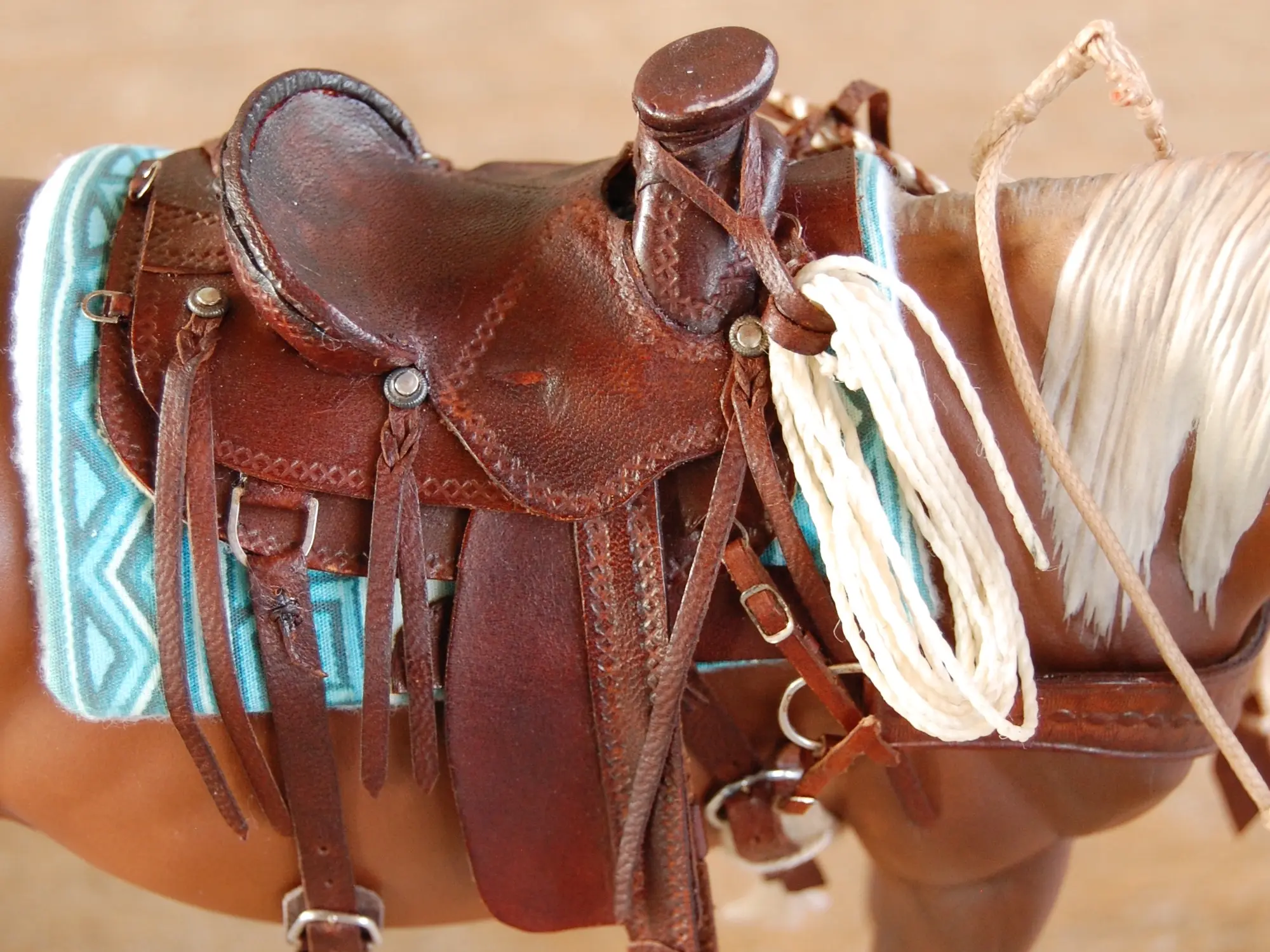 Model horse wearing miniature handmade saddle