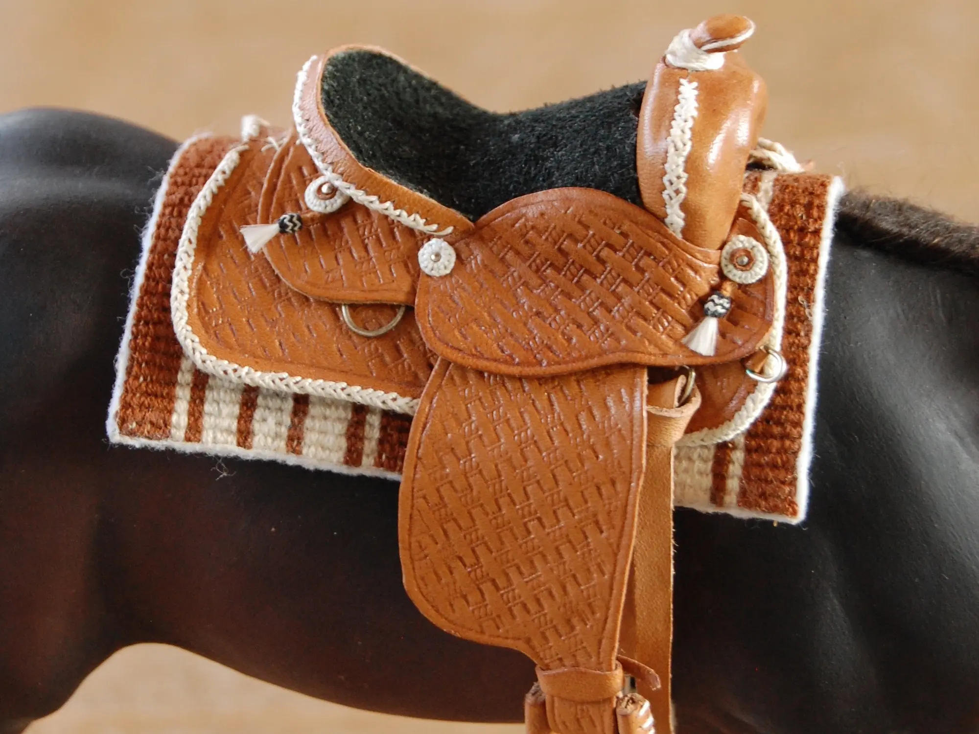 Model horse wearing miniature handmade saddle