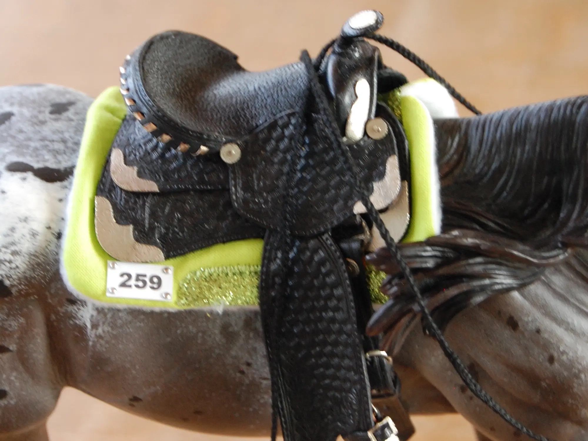 Model horse wearing miniature handmade saddle