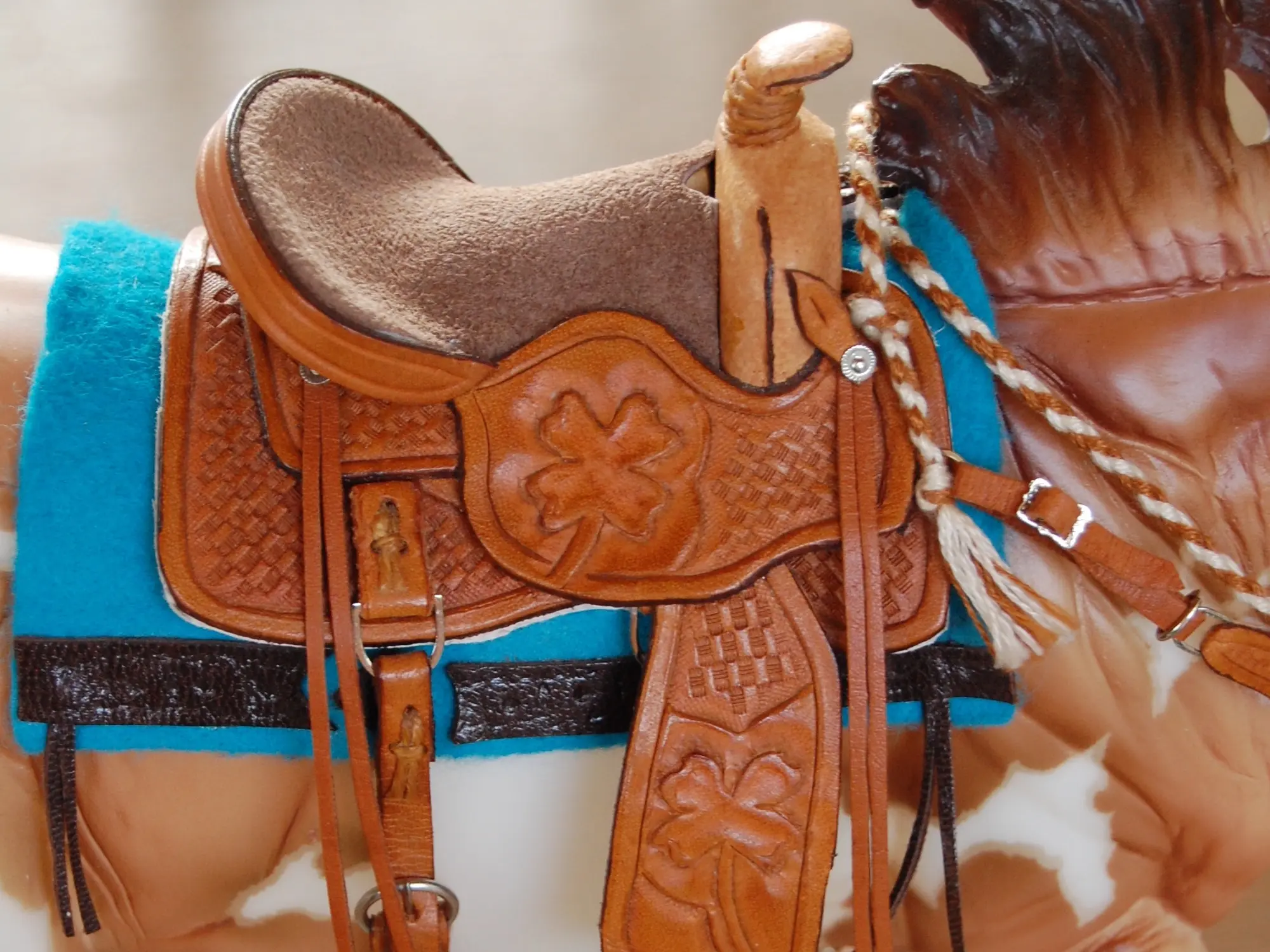 Model horse wearing miniature handmade saddle