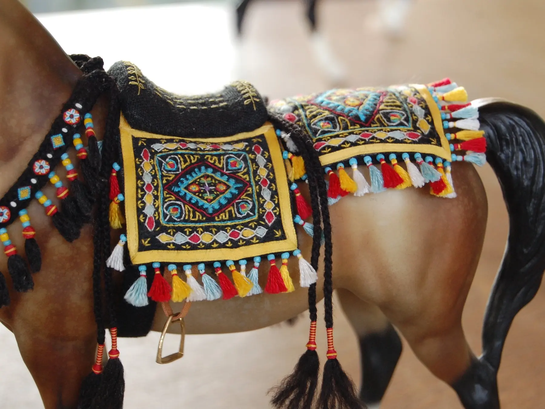 Model horse wearing miniature handmade saddle