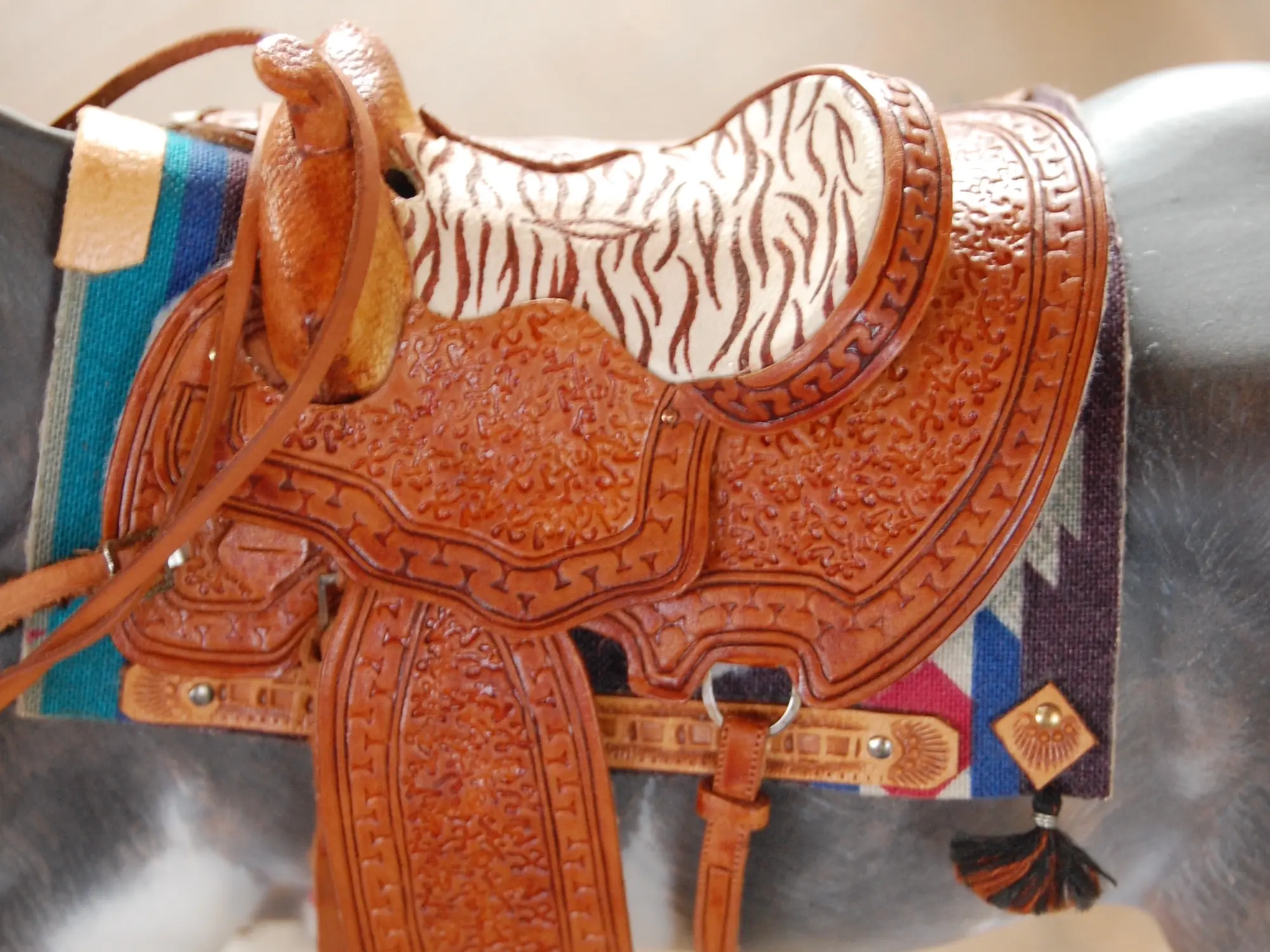 Model horse wearing miniature handmade saddle