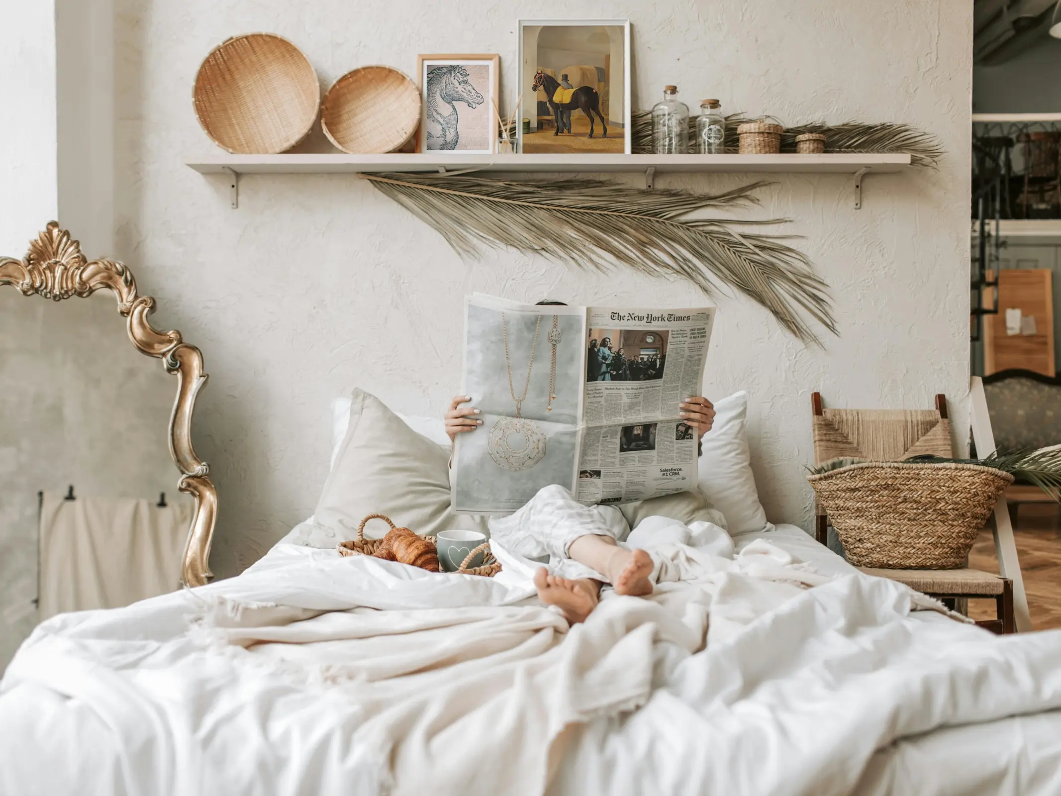 Woman lying in bed reading the newspaper