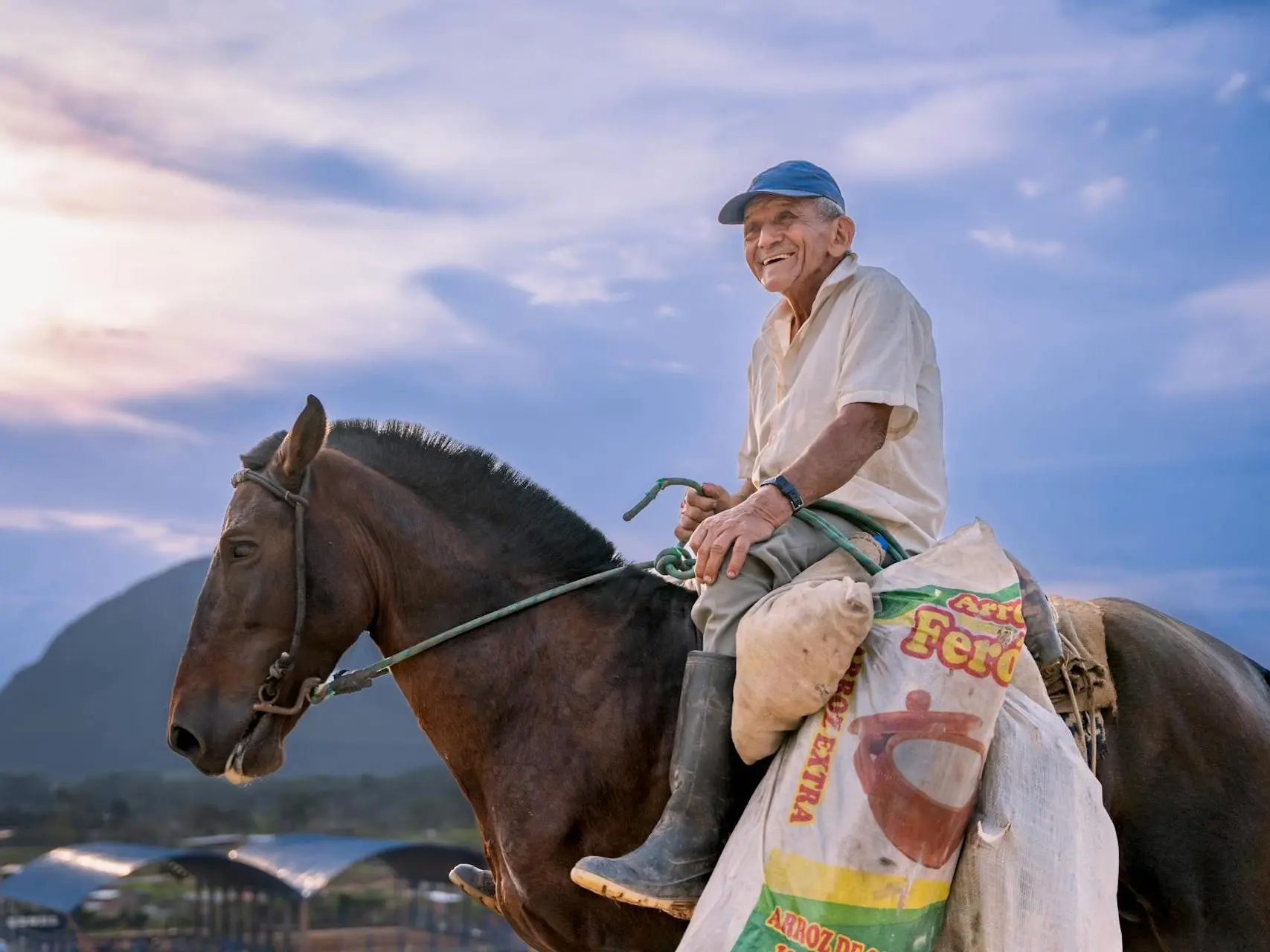 Man on a horse in the Peruvian mountains with sacks of food