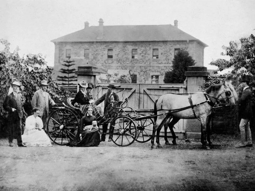 A family in a carriage in front of a building