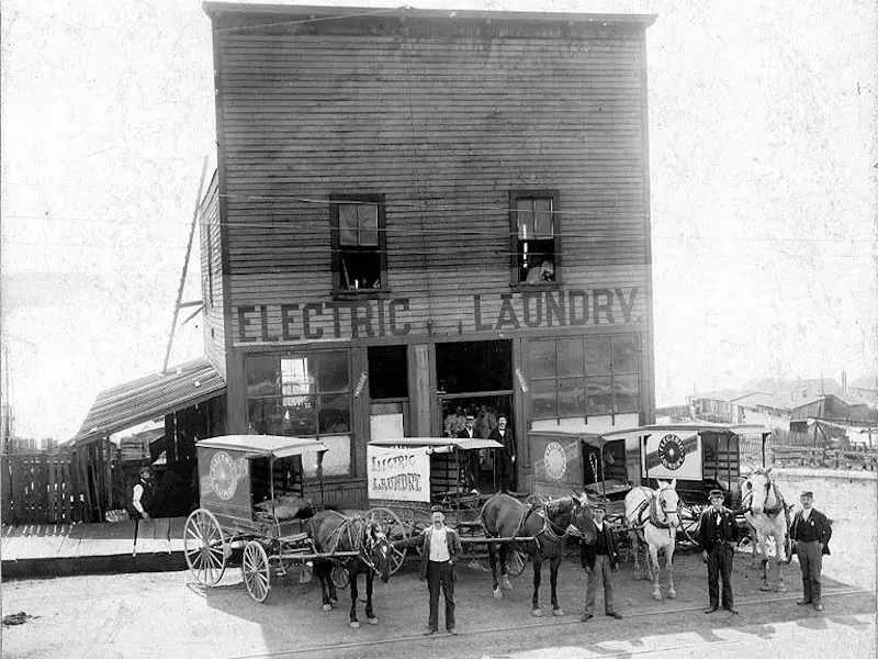 Men standing with wagons outside of a shop