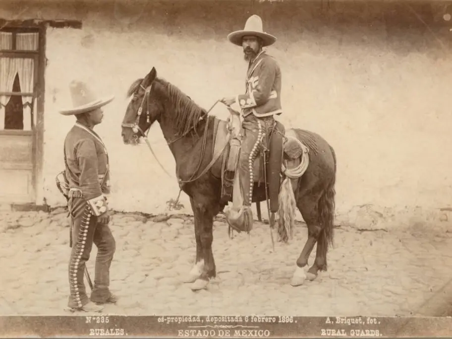 Two men in uniform, one mounted on a black horse