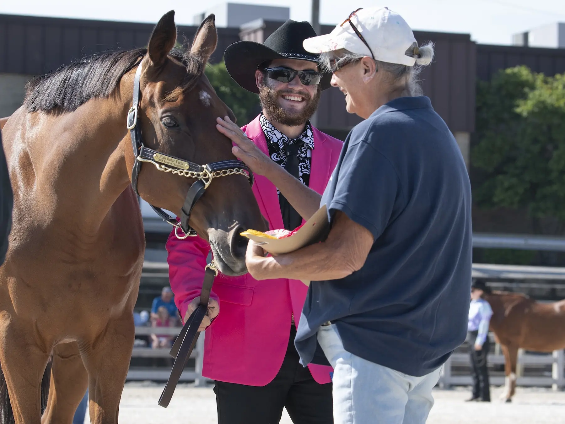 groom standing with a horse and man